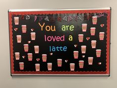 a bulletin board with coffee cups on it and the words you are loved a latte