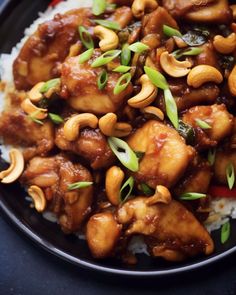 chicken and cashews on top of rice in a black bowl