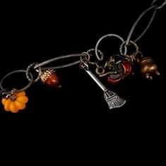 This fairytale witchy necklace is a magical piece intended for those with a heart and soul of fantasy and enchantment. The three-layered maple leaf pendant shimmers in rich fall tones: red, green, and yellow, symbolizing the beauty of autumn. The dangling magical charms include bronze cauldrons, witches with their cauldrons, and brooms - all adding a unique witchy vibe to this extraordinary necklace. Designer attention to detail - take a look into the cauldrons and you'll find a sparkling red cr Whimsical Dangle Charm Necklaces For Jewelry Making, Whimsical Halloween Dangle Jewelry, Bohemian Necklaces For Halloween Jewelry Making, Halloween Themed Pendant Necklace With Charms, Magical Charms For Jewelry Making, Whimsical Red Dangle Jewelry, Handmade Dangle Necklaces For Halloween, Whimsical Dangle Jewelry With Charms, Whimsical Vintage Charm Jewelry