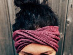 a close up of a person wearing a headband and looking down at her cell phone