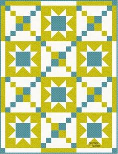 a blue and yellow quilt with white stars on the top, in front of a green background