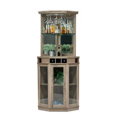 a tall wooden cabinet with glass doors and shelves filled with bottles, glasses and plants