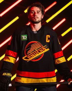 a hockey player is standing in front of neon lights with his hands on his hips