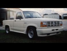 a white pickup truck parked in front of a house