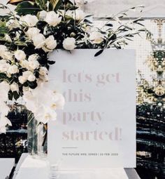 there is a sign that says let's get this party started with flowers in a vase