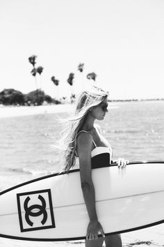 a woman carrying a surfboard on the beach