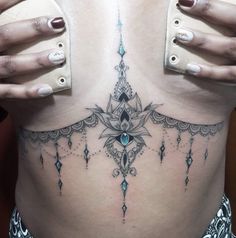 a woman's stomach with an intricate tattoo design on her belly and the bottom part of her lower back