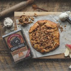 an apple pie sitting on top of a cutting board next to some other food items