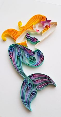 a paper cut out of a mermaid with long hair and starfish on it's tail