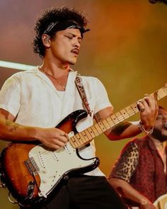 a man playing an electric guitar on stage