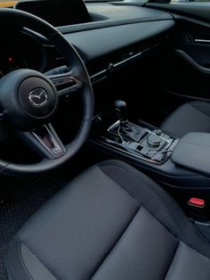 the interior of a car with black leather seats and steering wheel, dashboard controls and dash board