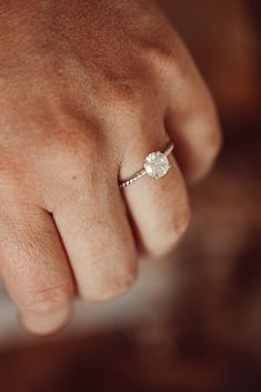 a person's hand with a diamond ring on it