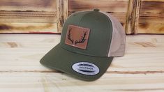 Deer hunter hat with precision leather etched patch with optional . The hats are the popular retro trucker style YP 6-panel snap-back that look great and are available in several colors - see available colors. Optional patch color: Light Brown Dark Brown Rawhide Hat Details: SIZE - Adult size with snap closure - One size fits most. DESIGN - Custom laser etched American flag patch with machine sewn edge MATERIAL - 65% polyester and 35% cotton. Vegan Friendly Leather Patch (Leatherette). SHIPS - I Leather Patch Trucker Hat For Camping, Classic Brown Trucker Hat For Outdoor, Casual Leather Snapback Hat With Curved Brim, Brown Hunting Hat With Leather Patch, Trucker Style Six-panel Baseball Cap With Leather Patch, Trucker Hat With Flat Bill For Hunting, Brown Leather Patch Hunting Hat, Western Style Snapback Hat For Outdoor, Brown Casual Baseball Cap For Hunting