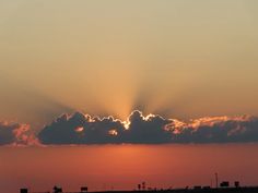 the sun is setting behind some clouds in the sky