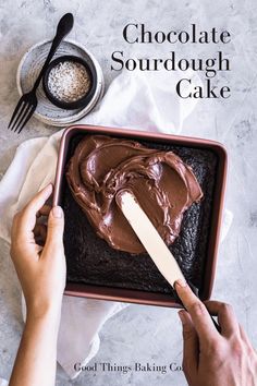 someone spreading chocolate on top of a cake