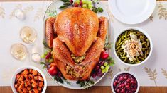 a large turkey sitting on top of a table next to bowls of food