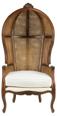 an old fashioned wicker chair with a white cushion on it's back end