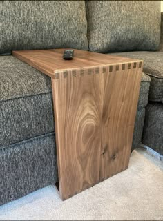 a wooden table sitting on top of a gray couch