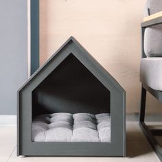 a dog house shaped bed sitting next to a chair