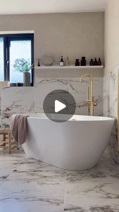 a bathroom with marble flooring and white bathtub in the center, surrounded by shelves