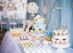 a table topped with lots of cakes and cupcakes