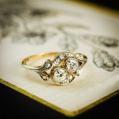 an antique diamond ring sitting on top of a piece of paper