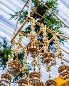 an elaborate chandelier hanging from the ceiling in a room with white flowers and greenery