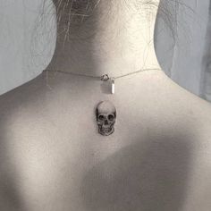 the back of a woman's neck with a skull on it