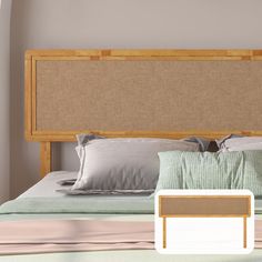 a bed with pillows and blankets on top of it next to a wooden headboard