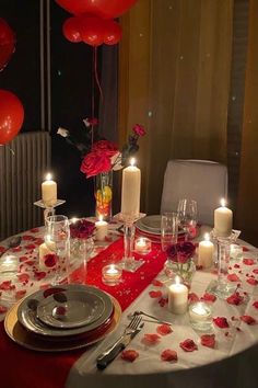 the table is set with candles, plates and napkins for an elegant valentine's day dinner