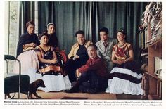 a group of people sitting next to each other in front of a window with green curtains