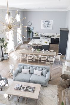 a living room filled with furniture and a large clock mounted to the wall above it