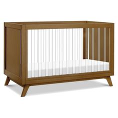 a wooden crib with a white sheet in the bottom half and wood trim around the sides