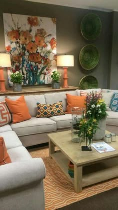 a living room filled with lots of furniture and flowers on top of a coffee table