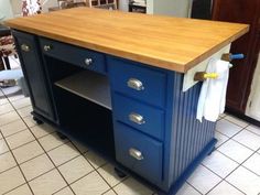 a kitchen island with two drawers and a cutting board on the top, in front of a tile floor