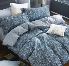 a bed with blue and white comforters in a bedroom