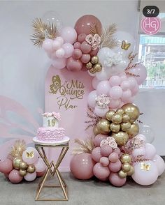 a pink and gold themed birthday party with balloons, cake and table decorations on display