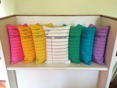 four colorful pillows sitting on top of a white shelf