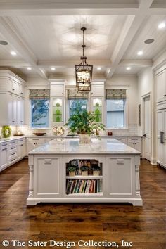 a large kitchen with white cabinets and an island in the center is surrounded by wood flooring