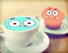 two cupcakes with faces on them sitting next to each other in saucers