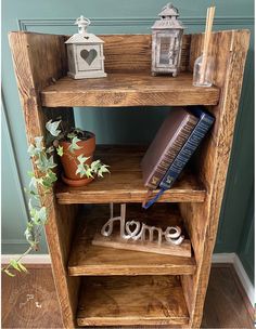 a wooden shelf with some books on top of it next to a potted plant