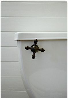 a white toilet with the lid up and an iron cross on it