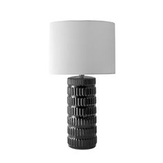 a black and white lamp with a white shade on the top, against a white background