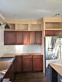 a kitchen with wooden cabinets and ladders in it