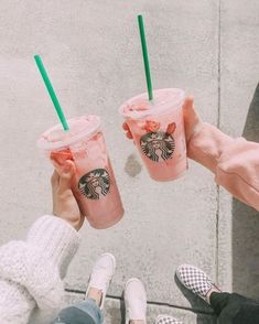 two people holding starbucks drinks in their hands