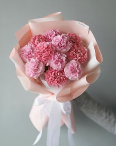 a bouquet of pink carnations wrapped in paper