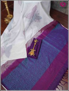 A pristine white soft silk saree featuring a tableau of butterfly patterns half adorned in royal purple threads and half in serene blue threads. The charming butterfly motifs dance across the fabric, creating a mesmerizing blend of grace and vibrancy. This borderless ethereal white saree leads to a captivating purple pallu that intricately unfolds into a tapestry of enchanting floral designs woven with delicate blue threads. This elegant combination captures the essence of sophistication, blendi White Silk Saree For Puja, White Silk Saree For Festivals, White Silk Handloom Traditional Wear, White Silk Dupatta With Traditional Patterns, White Silk Saree With Pallu, White Silk Saree With Zari Weaving, White Silk Saree With Motifs, White Art Silk Saree For Traditional Ceremonies, White Tissue Silk Traditional Wear With Zari Weaving