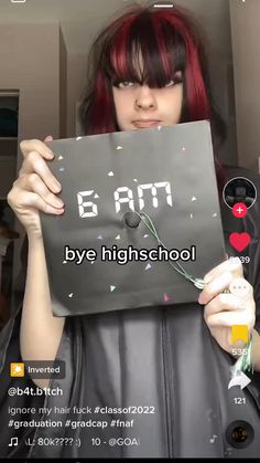 a girl with red hair holding up a sign that says e am by highschool