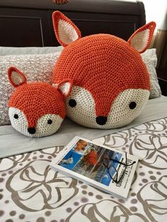 two knitted fox pillows on a bed