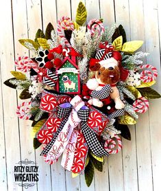 a christmas wreath with candy canes, candies and a teddy bear on it